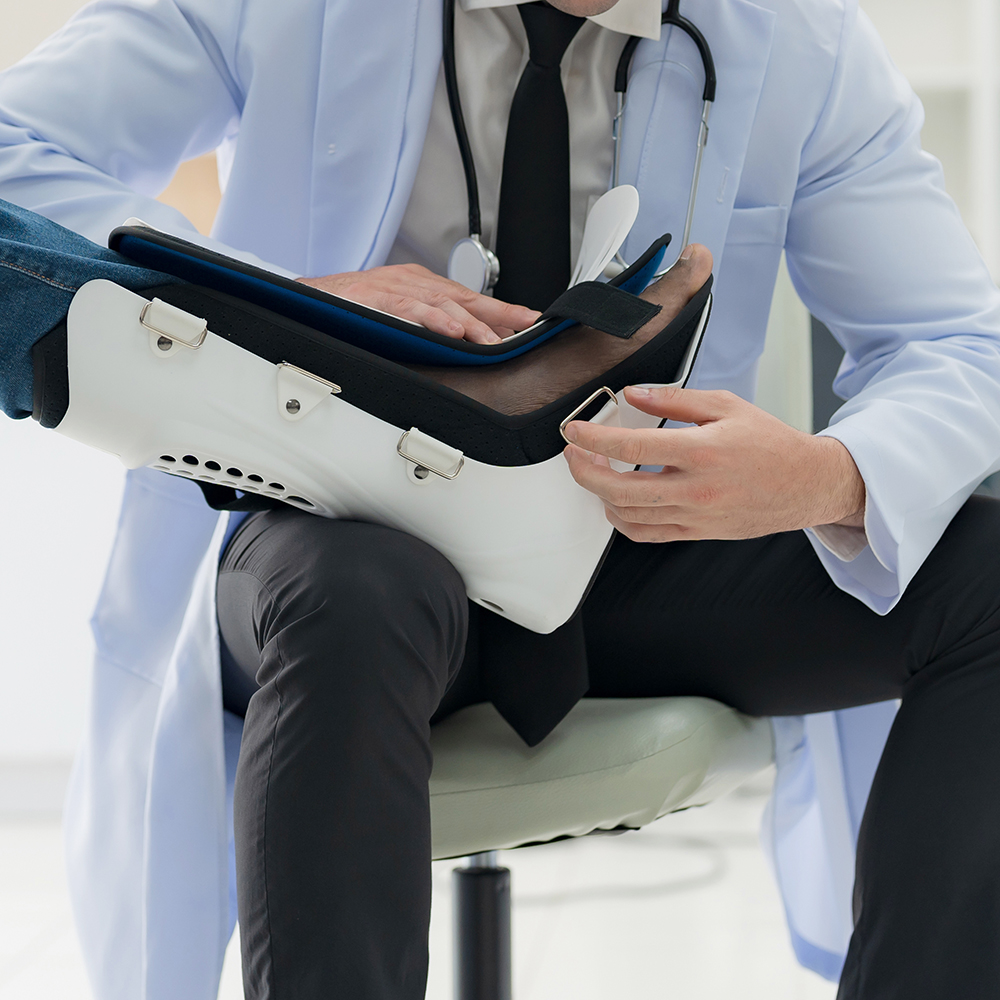 The doctor puts a splint on a patient with a leg injury.